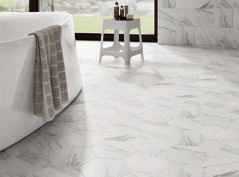 White hexagon porcelain floor tile next to a freestanding bathtub.