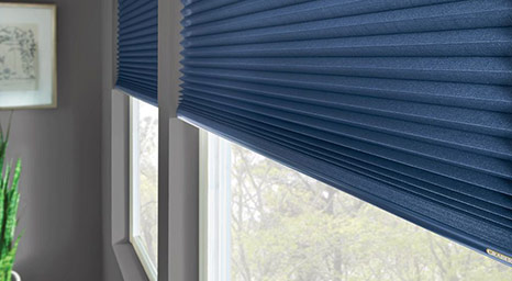 Close-up of dark blue pleated cellular window shades.