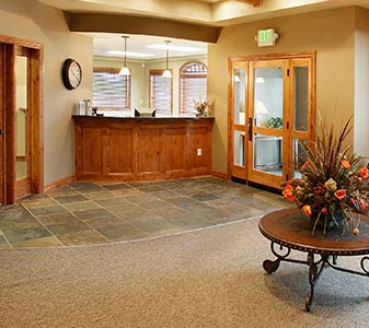Office lobby featuring a wooden reception desk, slate tile, and carpet flooring.